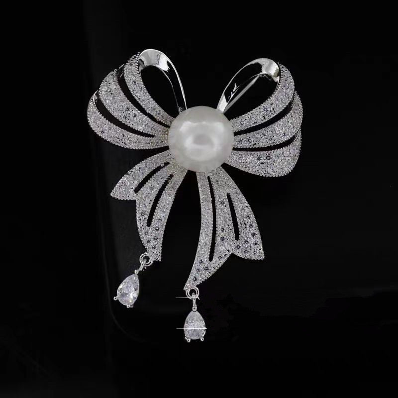 Image of stylish rhinestone brooch with pearl and ribbon design