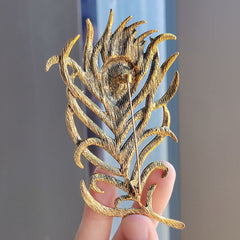 Close-up of colorful brooch with feather design image 3