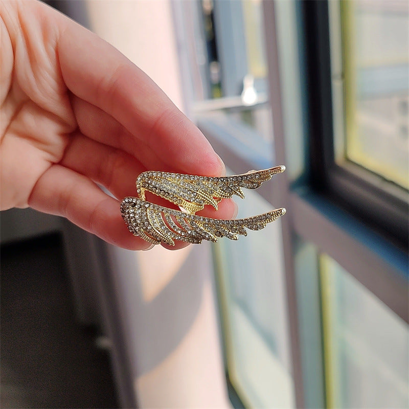 Elegant angel wings brooch displayed on stylish outfit