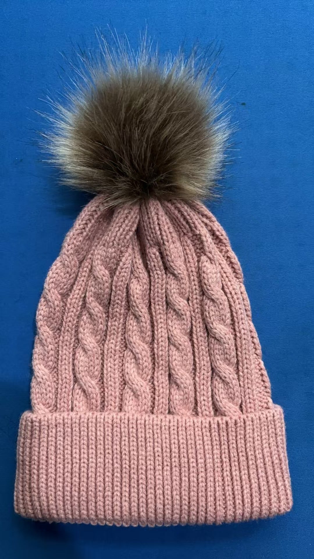 Dark grey knit beanie with pom pom displayed