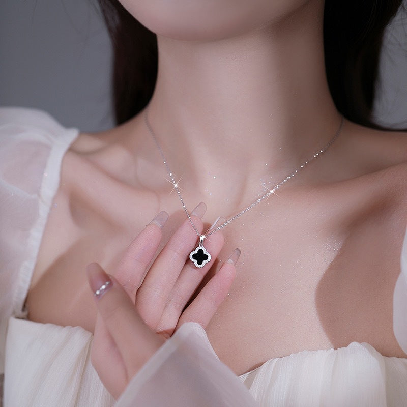 Four-leaf clover necklace lying on a marble surface